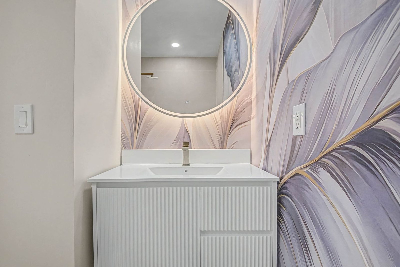 Floating vanity with champagne-brass fixtures in the renovated bathroom