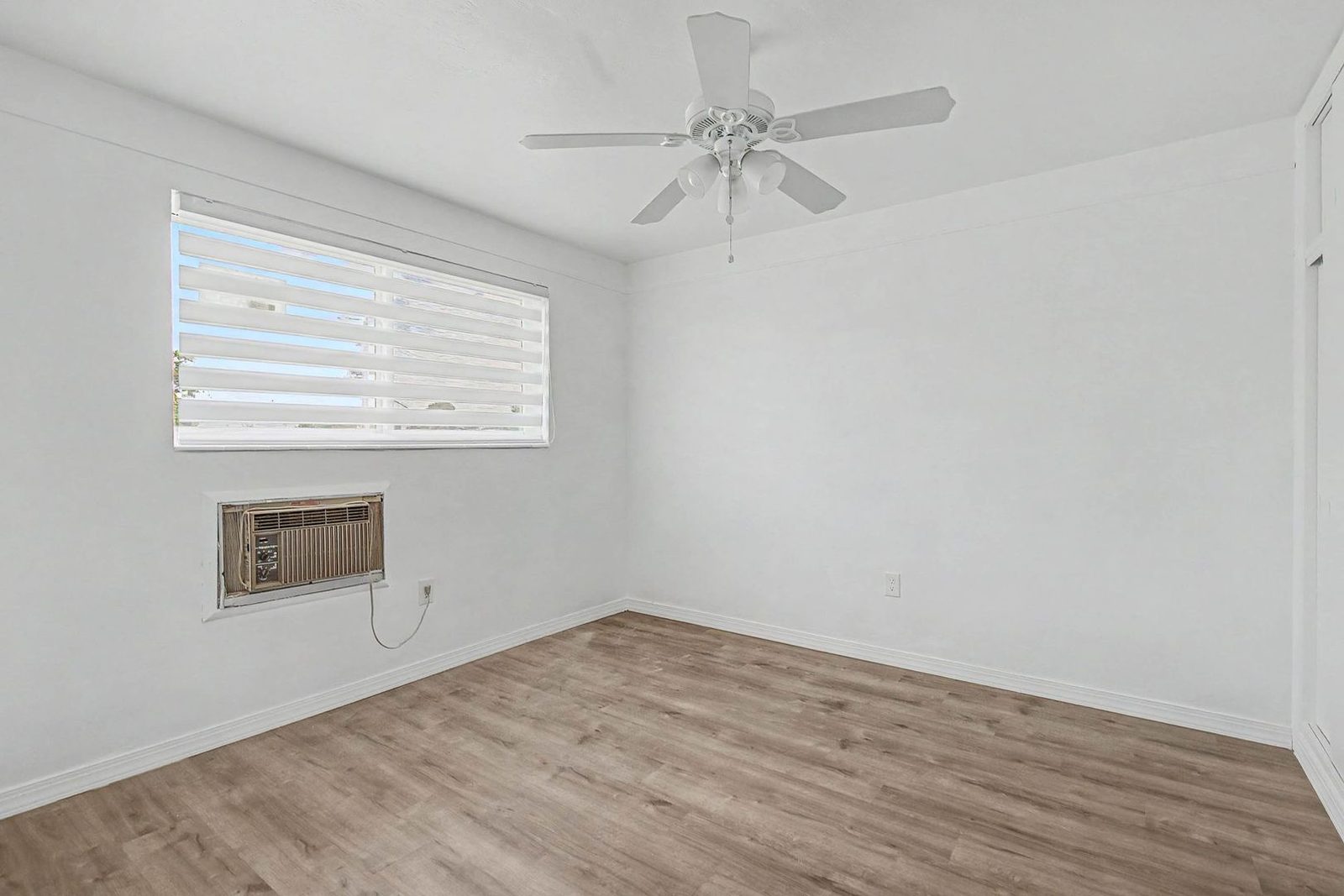 Bedroom with window and wood flooring