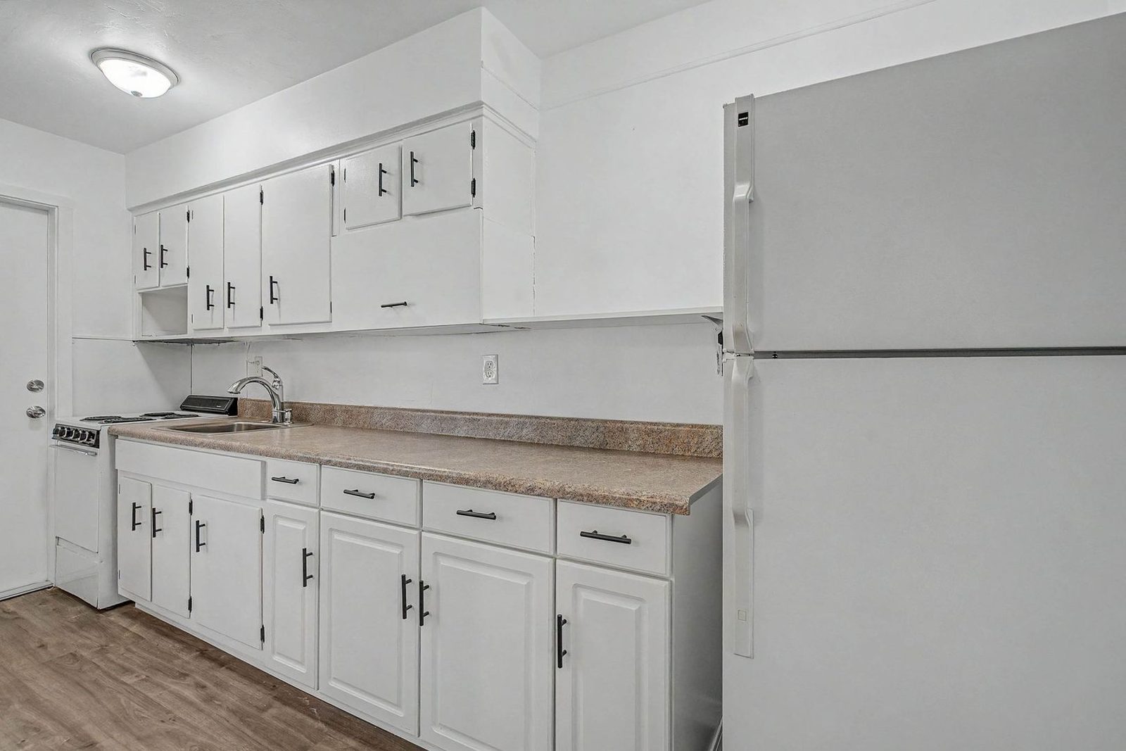 Kitchen with refrigerator and white cabinets
